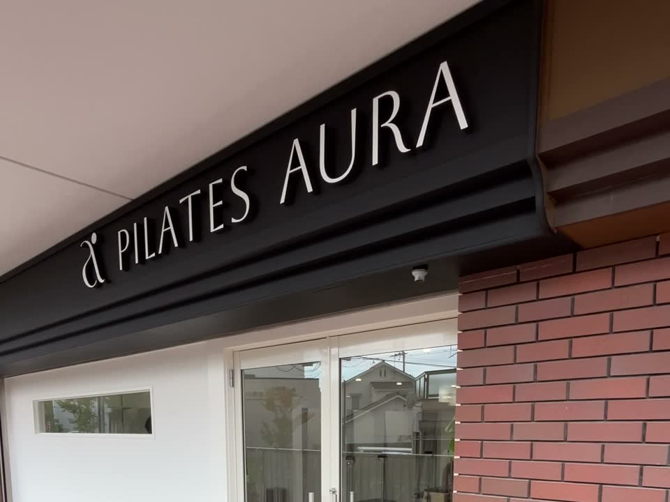 ピラティススタジオ アウラの入口と「PILATES AURA」の看板