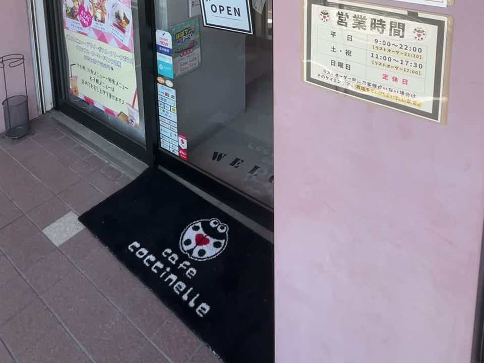 カフェコクシネルの入口。店名の入ったマットと営業時間の案内