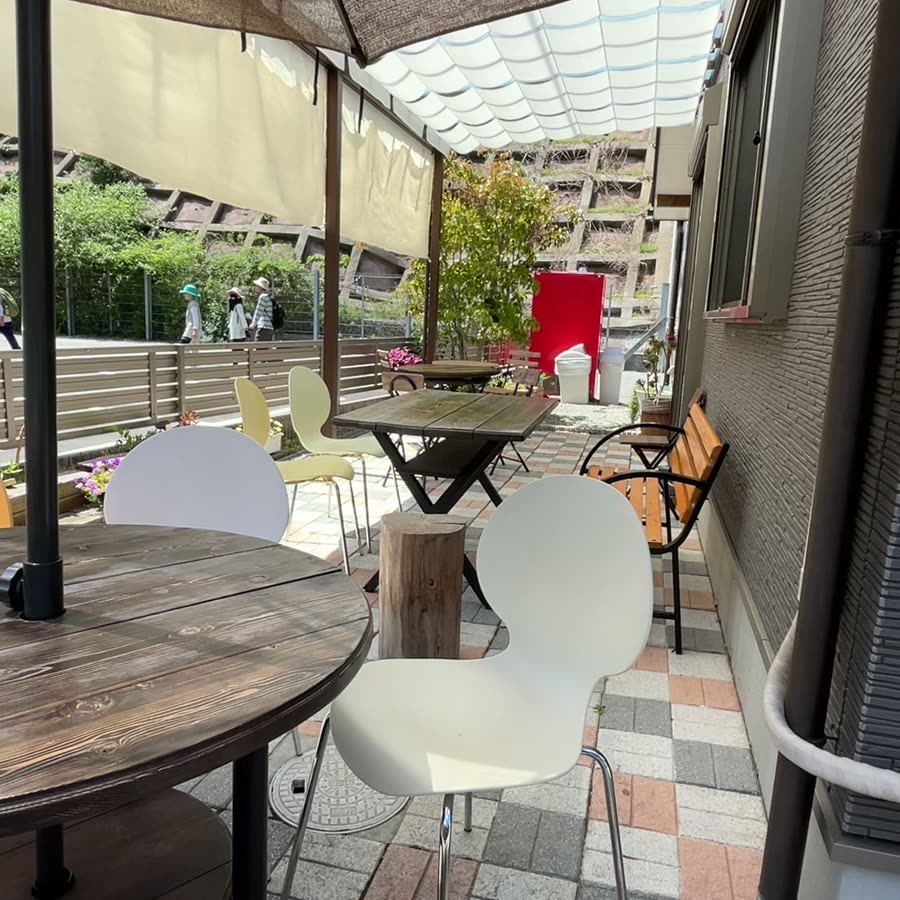 日よけのかかったテラス席と山あいの景色
